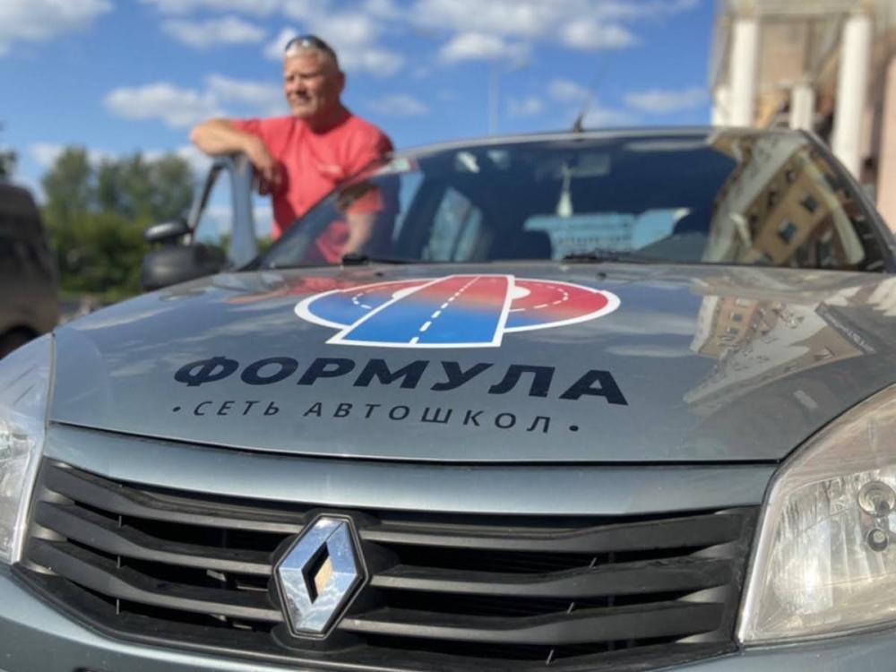 Вид из салона учебного автомобиля автошколы Формула на оживленную летнюю улицу Тюмени.